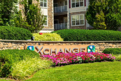 Vibrant flowers and well maintained lawn infront of the signage of the commercial property concept image for landscape market update